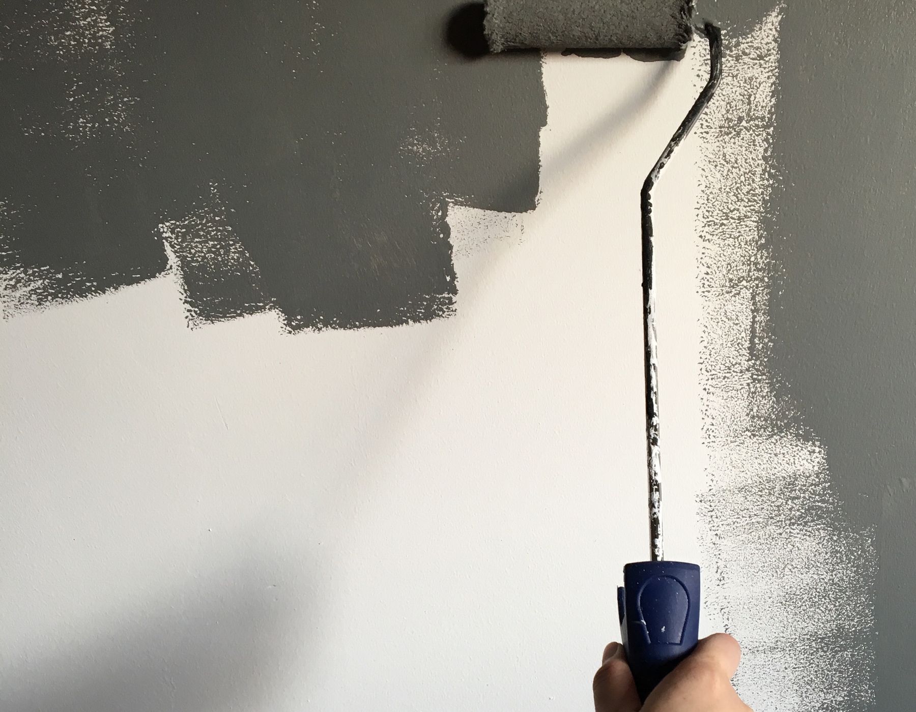 Painter rolling fresh paint onto an interior wall